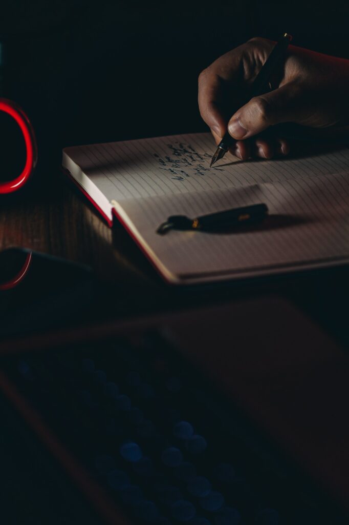 hand writing on a notebook in darkness