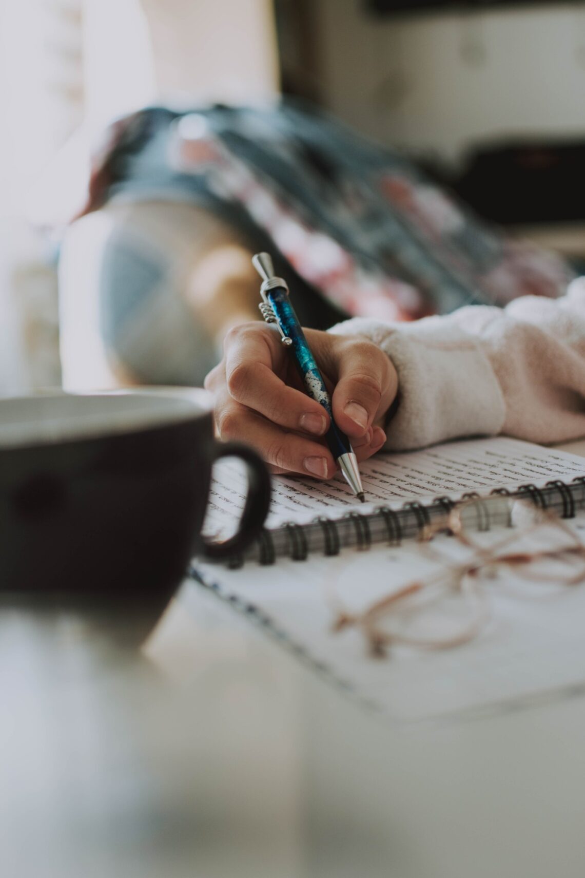 a hand writing on a notebook