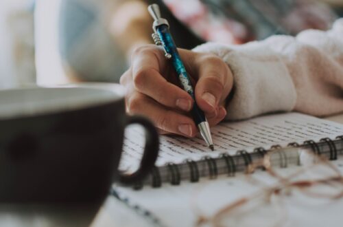 a hand writing on a notebook